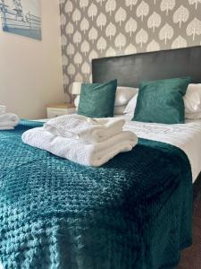 a bedroom with two beds with green pillows at Minworth Lodge in Minworth