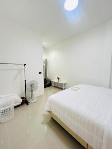 - une chambre blanche avec un lit blanc et un sol blanc dans l'établissement Hatyai city habibi home 1, à Sathani Hat Yai