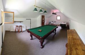 a room with a pool table and a staircase at Vila Carmen in Cazaci