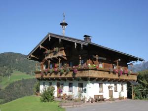 a house with a balcony with flowers on it at Apartment in Embach near Gastein Ski Area in Embach