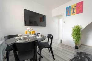 a dining room with a table and chairs and a tv at Comfort Meets Style, 4-Bedroom Home with All Essentials, Croydon, Sleeps 8! Contractor Friendly! in Thornton Heath