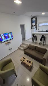 a living room with a couch and a tv on a wall at Departamento Elena 2 in Santa Rosa