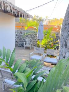 a patio with two chairs and an umbrella at Paillote Plume Bleue in Saint-Leu