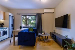 a living room with a blue couch and a tv at #AlimamaSpaces The Thando's Akaru in Johannesburg