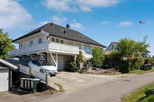 a house with a car parked in the driveway at Soltoppen- Lys og romslig villa på Nøtterøy 