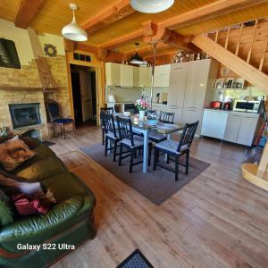 eine Küche und ein Wohnzimmer mit Tisch und Stühlen in der Unterkunft Brīvdienu māja Vāverītes  + 20 Fotos