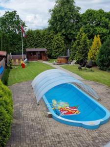 einen Pool mit Sonnenschirm im Hof in der Unterkunft Brīvdienu māja Vāverītes 