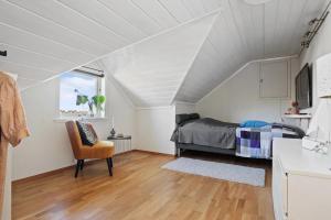 a attic bedroom with a bed and a window at Soltoppen- Lys og romslig villa på Nøtterøy 