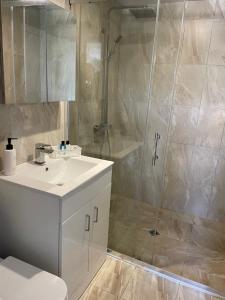 a bathroom with a white sink and a shower at Къща за гости (Залезът) in Tutrakan