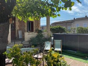 un giardino con sedie, tavolo e recinzione di Villa septembre logement VANILLE a Lamalou-les-Bains