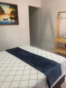 ein Schlafzimmer mit einem Bett, auf dem eine blaue Decke liegt in der Unterkunft Chalé Casa Moitas in Amontada