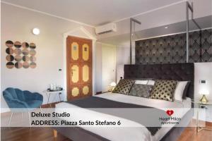 a bedroom with a large bed and a blue chair at Heart Milan Apartments Duomo District in Milan +262 photos