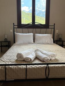 a bed with towels on it with a window at Villa Rozalia in Konitsa