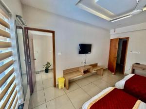 a room with two beds and a mirror and a tv at Ikigai Business Rooms by Zoliva Homes in Cochin