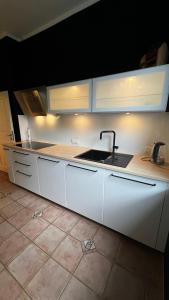 a kitchen with white cabinets and a sink at Ferienwohnung inmitten der Natur und Seen in Haltern