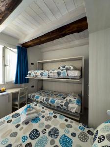 a bedroom with three bunk beds in a room at BelSorrisoVarese - Rooms & Apartments - Private Parking - Reservation Required in Varese