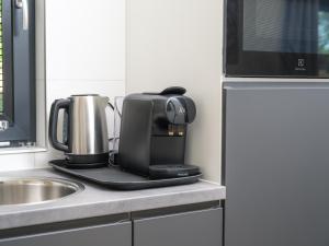 a coffee maker sitting on a counter next to a sink at Luxembourg Nature Retreat - Mamer Lodge in Fouhren