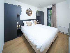 a bedroom with a large white bed and a window at Luxembourg Nature Retreat - Mamer Lodge in Fouhren