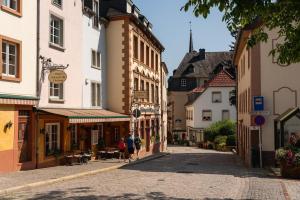 a street in a town with people walking down the street at Luxembourg Nature Retreat - Mamer Lodge in Fouhren