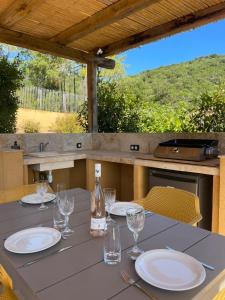 a table with plates and glasses and a bottle of wine at La BERGERIE de la CRIQUE BLEUE in Conca