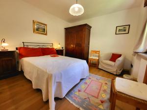 a bedroom with a large white bed and a chair at Molo 2 Pila in Gressan