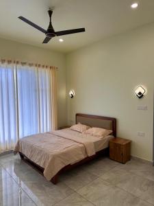 a bedroom with a bed with a ceiling fan at Vista valley in Kattappana