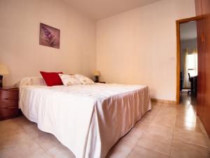 - une chambre avec un lit doté de draps blancs et d'oreillers rouges dans l'établissement Piso capital La Mariposa, à Santa Cruz de Tenerife