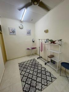 a room with a ceiling fan and a clock on the wall at Homestay Hanan in Kuala Terengganu