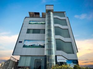 a tall building with a blue sky in the background at Hotel One DG Khan in Taunsa