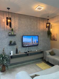 a living room with a flat screen tv on a wall at Boa Vista Apartment in Joinville