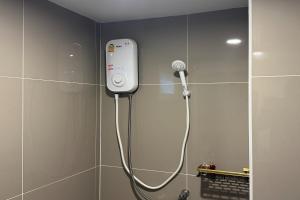 a bathroom with a shower with a phone on the wall at Eastan Golf View ChiangMai in Chiang Mai +17 photos