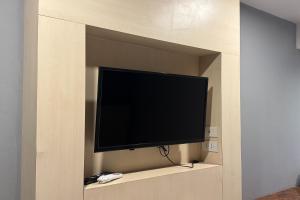 a flat screen tv sitting in a cabinet at Eastan Golf View ChiangMai in Chiang Mai