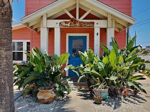 a restaurant with plants in front of a building at Royal Palm in Port Aransas