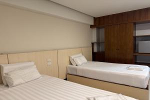 a hotel room with two beds and a cabinet at Eastan Golf View ChiangMai in Chiang Mai