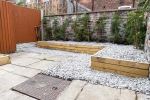 a garden with white rocks and a fence at Perfect Booking Stylish 2 Bed Home In Stockport in Manchester