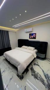 a large bed in a room with a marble floor at Alraja89 in Kafr Abū ʼumaydah