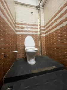 a bathroom with a toilet in a wooden wall at T Heritage Hotel in Chheonki