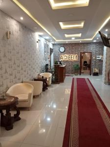 a lobby with a red carpet and a salon at Adeem Serviced Apartments in Buqayq