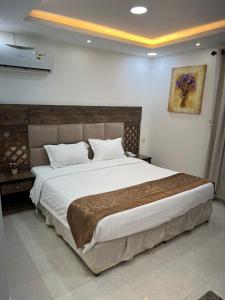 a bedroom with a large bed in a room at Adeem Serviced Apartments in Buqayq +21 photos
