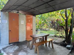 a picnic table and two benches sitting under a shed at Villagracia Homestay in Mambajao +14 photos