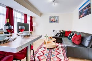 a living room with a couch and a table with wine glasses at Sleeps4-FreeParking-Pets-Wifi-Tottenham Stadium in London