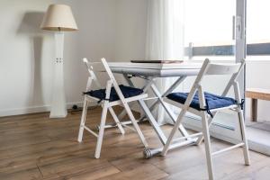 a dining room table with two chairs and a lamp at Joli studio avec balcon - 2 personnes in Les Sables-dʼOlonne