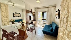 Una sala de estar con una mesa de cristal y un sofá azul. en Residencial João Orisaka, en Samaritá