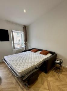 a bedroom with a bed in a room with a window at La suite d'Orbigny en hyper centre in La Rochelle