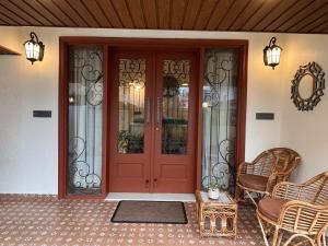 a red front door of a house with two chairs at Prantara in Dehradun