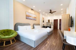 a hotel room with two beds and a tv at Misa House - Starlit Saigon in Ho Chi Minh City