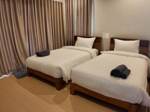 two beds in a hotel room with towels on them at แอเรียวา พูลวิลล่า ชะอำ Areava Pool Villa Cha am in Cha Am +15 photos