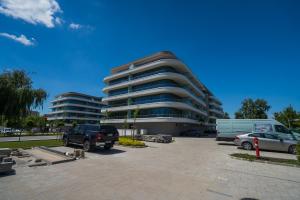 a parking lot with cars parked in front of a building at MyFlat Wave Beach39 Apartment in Siófok