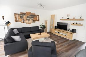 a living room with a couch and a tv at Gästehaus Lean in Potsdam
