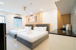 two beds in a room with a kitchen at Misa House - Starlit Saigon in Ho Chi Minh City